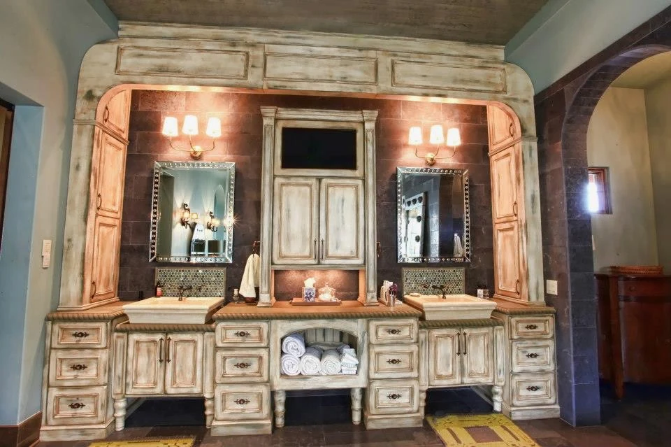 Custom double vanity with distressed wood millwork and twin vessel sinks